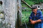 A local farmer pauses to wash his hands at a natural spring at Sanguinho on the island of Sao Miguel,Azores