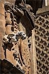 Spain,Andalucia,Seville. A gargoyle forms part of a coat of arms on the wall of Seville Cathedral.