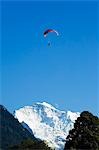 Ein Gleitschirm fliegt über ein Mond erhebt sich über die Bergkette der Jungfrau, Interlaken, Jungfrau Region, Schweiz