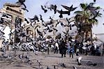 Feeding the pigeons in front of the remains of the Roman Western Temple Gate outside the Umayyad Mosque,Damascus,Syria