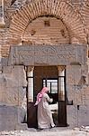 A warden opens the ruined Byzantine church at Qasr ibn Wardan,Syria,which dates back to the 5th century. Byzantine characters can been seen on the lintel.