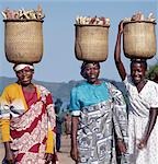 Un groupe de femmes gaies transporter de patates douces au marché dans des paniers traditionnels de split-bambou en équilibre sur leurs têtes.