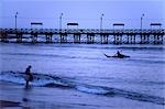 A Huanchaco fisherman returns to shore paddling a traditional totora (reed) boat,known as a caballito de totora (little horse of reeds).