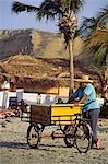 A snack vendor awaits customers,on the sands at Mancora in northern Peru.