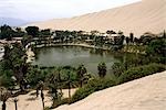 The oasis village of Huacachina,near Ica is southern Peru. The lagoon,backed by giant sand dunes,is a popular tourist destination and is featured on the S/50 banknote.