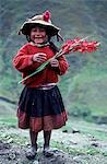 Une fille de Runa exhibe fièrement un glaïeuls. Avec les couleurs ternes du paysage comme toile de fond, l'amour de natifs de couleurs vives et particulièrement des fleurs est particulièrement clair.