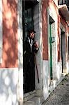 Old man leaning in his door with his cigarette watching the world go by,Lisbon,Portugal