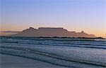 Surf roule sur une plage déserte près de Bloubergstrand à Cape Town et de la montagne de la Table derrière