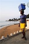 A street seller walks along the 'Baia de Ana Chaves' (Bay of Ana Chaves. Ana Chaves was a renowned rich black slave trader who lived in sao Tomé in the 1600's). Sao Tomé and Principé is Africa's second smallest country with a population of 193 000. It consists of two mountainous islands in the Gulf of New Guinea,straddling the equator,west of Gabon.