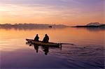 Kayakers paddle the calm waters of Alaska's Inside Passage with Herbert Glacier in the background at sunset, Tongass National Forest near Eagle Beach State Recreation Area.