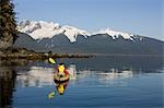 Kayakiste palettes du rivage sur une après-midi calme à Lynn Canal, juste à l'extérieur de la baie de Berners en Tongass forestier Alaska, Inside Passage.