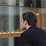 man looking at jewelry in shop window