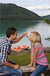 A young couple having a picnic by a lake