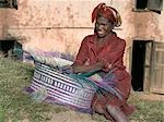 A Malagasy woman weaves a basket from raffia palm.