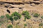 Mali, Dogon-Land, Banani. Teil der Dogon Dorf von Banani befindet sich am Fuße des die 120 km langen Bandiagara Böschung. Die Dogon, die Beerdigung Höhlen sind in den fast unzugänglichen steilen Sandsteinfelsen hinter dem Dorf gelegen. Die Höhlen dienten ursprünglich durch die Tellem, die heraus von den Dogon im fünfzehnten Jahrhundert vertrieben wurden.