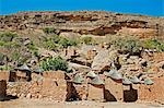 Mali,Dogon Country,Koundu. The attractive Dogon village of Koundu built among rocks beneath a sandstone cliff of the 120-mile-long Bandiagara escarpment. Dwellings have flat roofs while the numerous granaries to store millet have pitched thatched roofs.