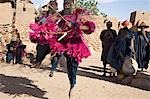 Au Mali, pays Dogon, ce. Danseurs masqués sautent en l'air dans le village Dogon de ce qui se trouve parmi les rochers au pied de l'escarpement de Bandiagara spectaculaire 120 milles de longueur. La danse de masque est exécutée lors de cérémonies funéraires pour apaiser les morts et leur vitesse en route vers le monde ancestral.