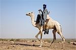 Mali, Timbuktu. Touareg fier manèges son chameau à travers les terrains pierreux semi-désertique près de Tombouctou.