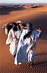 Berber tribesmen lead their camels through the sand dunes of the Erg Chegaga,in the Sahara region of Morocco.