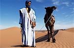 Un membre de la tribu berbère mène son chameau dans les dunes de l'Erg Chegaga, dans la région du Sahara du Maroc.