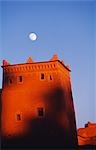 Moonrise over the castellated tower of the Taourirt Kasbah at sunset,Draa Valley,Ouazazate,Southern Morocco.