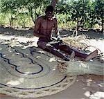 A man makes attractive floor mats from dried palm fronds near Liwonde. .
