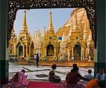 Myanmar, Burma, Yangon. Gläubige Buddhisten beten an den kleinen Stupas, Tempel, Schreine, Gebet Hallen und Pavillons an der Shwedagon Golden Temple.