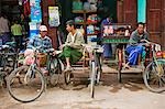 Myanmar. Burma. Nyaung U. The owners of bicycle taxis with sidecars,known as trishaws,relax as they wait for customers at Nyaung U market.