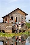 Myanmar,Burma,Lake Inle. A typical Intha wooden house on stilts in Lake Inle,picturesquely sheltered by mountains rising to 1,524 metres.