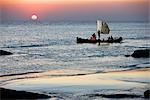 Myanmar, Burma, Rakhaing-Staat. Die Crew von einem Fischerboot eilt Startseite, Sittwe, Sonnenuntergang über der Bucht von Bengal.
