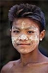 Myanmar,Burma,Mrauk U. A youth of the Rakhine ethnic group with his face decorated with Thanakha,a popular local sun cream and skin lotion.