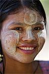 Myanmar, Burma, Mrauk U. Ein ziemlich junges Mädchen der ethnischen Gruppe der Rakhine mit ihrem Gesicht verziert mit Thanakha, eine populäre lokale Sonnencreme und Körperlotion.