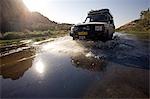 Namibia,Damaraland. Driving in a four wheel drive vehicle down the Ugab River near Brandberg Mountain in search of elusive Desert Elephants.