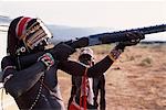 Samburu moran (guerrier) tente de la sensation d'un fusil de chasse à la fin d'un oiseau tir safari.