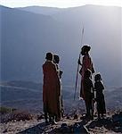 Comme le soleil se lève au-dessus des sommets boisés du Mont Nyiru, membres d'une famille de Turkana discuter et planifient les activités de la journée.