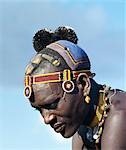 Un homme de Turkana avec une coiffure de terre fine, si typique du Sud Turkana. Les pompons de plumes d'autruche noires indiquent que l'homme fait partie de la portion ng'imor (noir) de sa tribu.