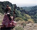 A Samburu homeguard looks out over the steep-sided gorge of Mount Kulal,which divides the mountain into two. Volcanic in origin,Mount Kulal rises to over 6,000 feet in Northern Kenya and is surrounded by a sea of lava and arid wastes. The mountain is forested on top and is a vital water resource. It's open grasslands give pastoralists good grazing for their livestock.