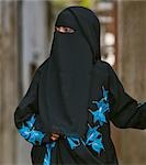 Kenia, Lamu Insel Lamu. Eine muslimische Frau Lamu Stadt Buibui oder Gesicht Schleier aber gekleidet in eine attraktive bestickten schwarzen Kleid zu tragen.