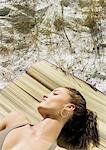 Young woman sleeping on beach mat
