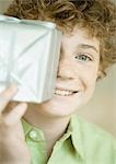 Boy holding up present in front of face