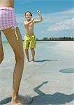 Boy and girl playing ball on beach