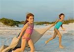 Zwei Mädchen am Strand laufen halten Decke draußen im wind