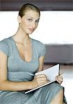 Young businesswoman writing in agenda