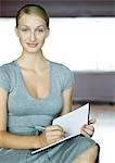 Young businesswoman writing in agenda