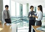 Business colleagues standing with cups of coffee, chatting