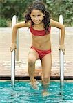 Mädchen stand auf Schwimmbad-Leiter, lächelnd in die Kamera