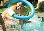 Father and children splashing in swimming pool