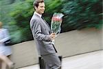 Businessman carrying bouquet of flowers