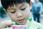 Boy holding süßen Snack, close-up