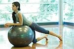 Jeune femme au repos sur le ballon de fitness